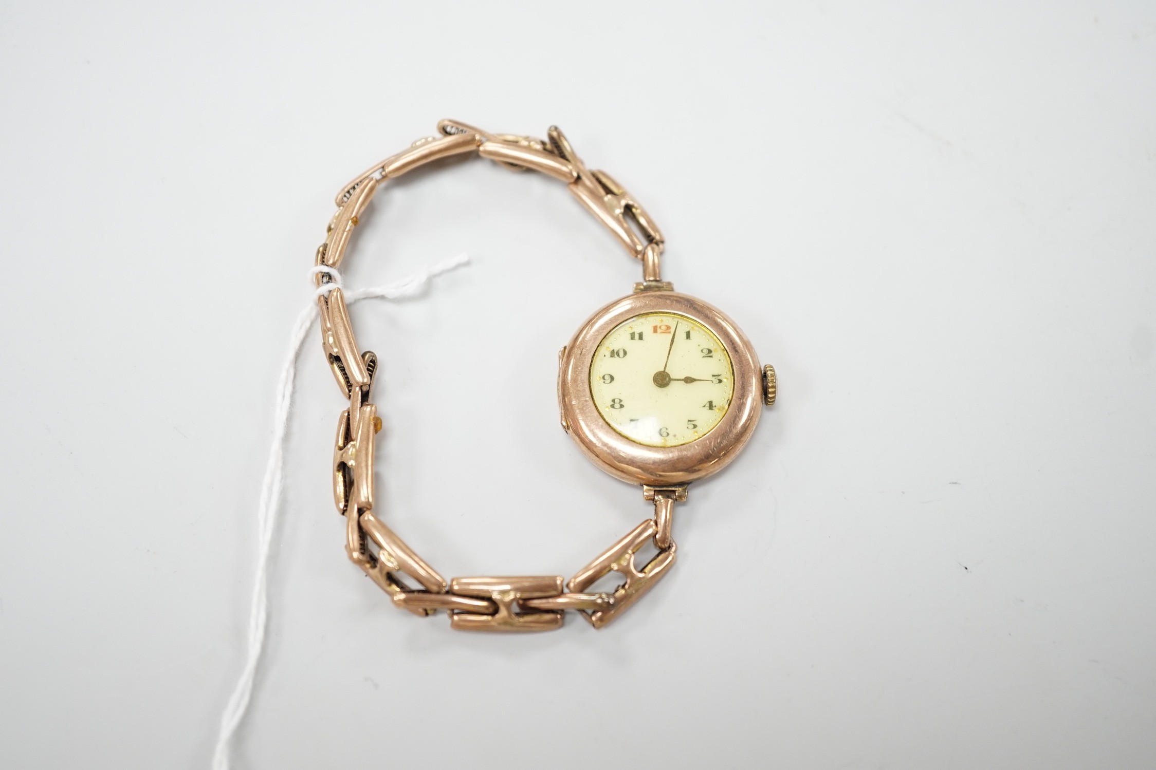 An early 20th century 9ct gold Rolex manual wind wrist watch, with Arabic dial, case diameter 27mm, on an expanding yellow metal bracelet, gross weight 22.1 grams.